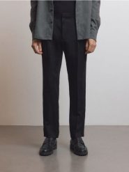 Spodnie slim fit z zakładkami - czarny. Czarne spodnie materiałowe męskie Reserved, bez wzorów, z bawełny. W wyprzedaży za 99.99 zł.