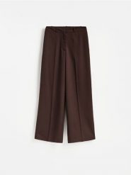 Spodnie z dodatkiem wiskozy - ciemnobrązowy. Brązowe spodnie materiałowe damskie Reserved, bez wzorów, z tkaniny. Za 129.99 zł.