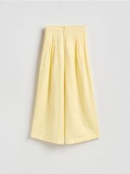 Lniane spodnie z zakładkami - jasnożółty. Żółte spodnie materiałowe damskie Reserved, bez wzorów. Za 169.99 zł.