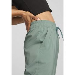 Damskie spodnie LACE PUMA Green Moon. Zielone spodnie dresowe damskie Puma, bez wzorów, sportowe, z podwyższonym stanem. W wyprzedaży za 210.05 zł.