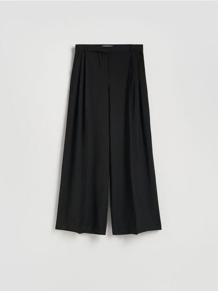 Spodnie z szerokimi nogawkami - czarny. Czarne spodnie materiałowe damskie Reserved, bez wzorów, z tkaniny. W wyprzedaży za 119.99 zł.