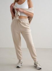 Damskie spodnie dresowe regular fit, ściągacze Comfy Modal beżowe. Białe spodnie sportowe damskie Aim'n, xl, z dresówki, na fitness i siłownię. Za 339.00 zł.