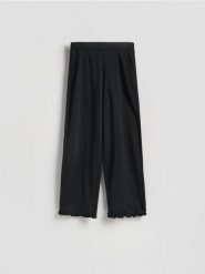 Bawełniane spodnie z falbanką - czarny. Czarne spodnie materiałowe damskie Reserved, bez wzorów, z bawełny. Za 99.99 zł.