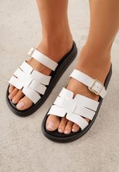 Białe Klapki z Przeplatanymi Paskami i Klamrą Ravelya. Białe klapki damskie Born2be, bez wzorów, z jeansu, bez obcasa, na płaskiej podeszwie. Za 79.99 zł.