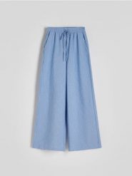 Szerokie spodnie w stylu piżamowym - niebieski. Niebieskie spodnie materiałowe damskie Reserved, bez wzorów, z bawełny. W wyprzedaży za 49.99 zł.