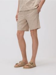 Szorty regular fit - kremowy. Białe szorty męskie Reserved, z bawełny, bez kołnierzyka. Za 129.99 zł.