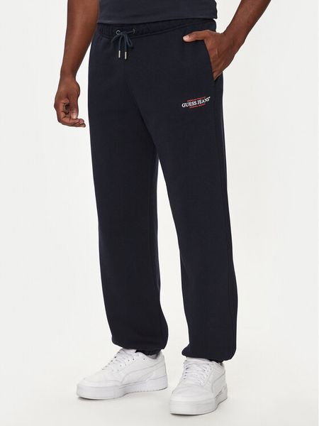 Guess Jeans Spodnie dresowe M4YB18 K9V31 Granatowy Regular Fit. Niebieskie spodnie dresowe męskie Guess Jeans, z aplikacjami, z bawełny. Za 239.99 zł.