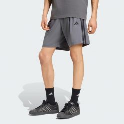 Szorty z tkaniny Essentials 3-Stripes Chelsea Lite. Białe szorty męskie Adidas, z materiału, bez kołnierzyka. Za 119.00 zł.