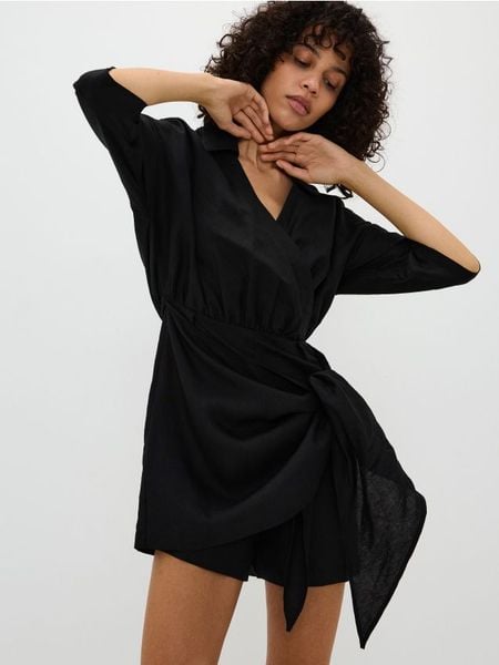 Kopertowy kombinezon z wiązaniem - czarny. Czarne kombinezony damskie Reserved, l, bez wzorów, z wiskozy, bez kołnierzyka, bez ramiączek. W wyprzedaży za 69.99 zł.