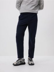 Spodnie joggery - granatowy. Niebieskie spodnie materiałowe męskie Reserved, bez wzorów, z bawełny. W wyprzedaży za 89.99 zł.