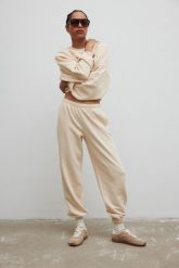 Spodnie typu jogger z HAFTEM w kolorze BISQUIT - NEVIS-XS. Brązowe spodnie materiałowe damskie Marsala, bez wzorów, z bawełny, eleganckie. Za 279.90 zł.