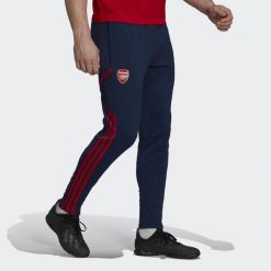 Spodnie do piłki nożnej męskie Adidas Arsenal Condivo 22 Training Pants. Niebieskie spodnie dresowe męskie Adidas, bez wzorów, z dresówki. W wyprzedaży za 190.50 zł.
