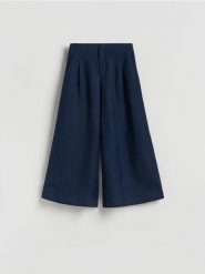 Spodnie z szerokimi nogawkami - granatowy. Niebieskie spodnie materiałowe damskie Reserved, bez wzorów, z tkaniny. Za 129.99 zł.