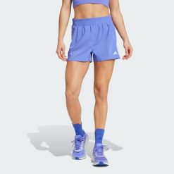 Szorty Own the Run. Niebieskie szorty damskie Adidas, bez wzorów, z materiału, klasyczne, z standardowym stanem. Za 189.50 zł.