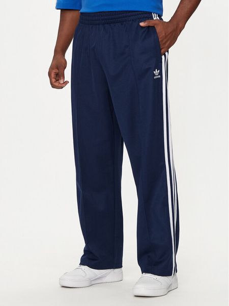 Adidas Spodnie dresowe adicolor Firebird IZ2466 Granatowy Baggy Fit. Niebieskie spodnie dresowe męskie Adidas, bez wzorów, z bawełny. Za 209.99 zł.
