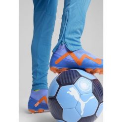 Spodnie treningowe Manchester City 2024/25. Niebieskie spodnie materiałowe męskie Puma, bez wzorów, sportowe. W wyprzedaży za 252.25 zł.