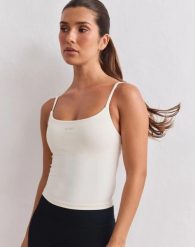 Damski top na ramiączkach modelujący Sculpting kremowy. Białe topy sportowe damskie Aim'n, l, bez wzorów, z dzianiny, bez ramiączek. Za 261.00 zł.