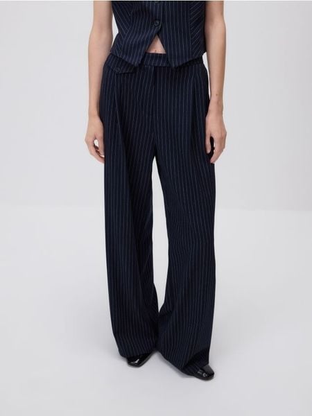 Spodnie w prążek - granatowy. Niebieskie spodnie materiałowe damskie Reserved, bez wzorów, z tkaniny. W wyprzedaży za 99.99 zł.