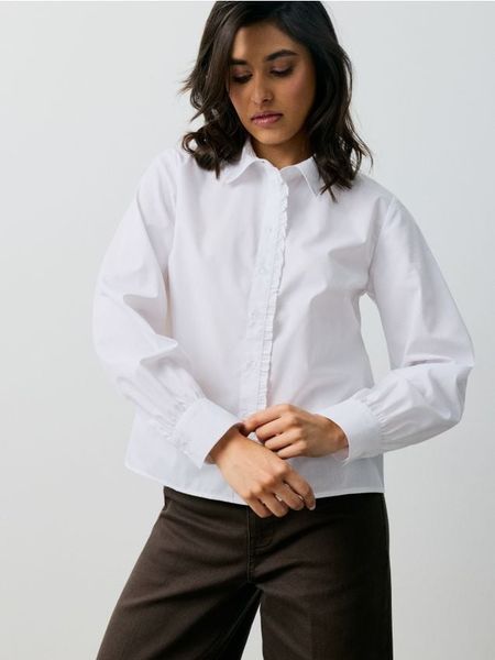Bawełniana koszula z falbaną - biały. Białe koszule damskie Sinsay, l, bez wzorów, z bawełny, bez kołnierzyka, bez ramiączek. Za 49.99 zł.