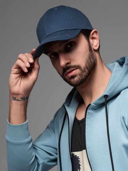Jednokolorowa czapka męska bejsbolówka z daszkiem – granatowa V2. Niebieskie czapki męskie Ombre Clothing, bez wzorów, z bawełny, klasyczne. Za 99.99 zł.