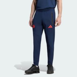 Spodnie FC Bayern Muenchen Tiro Travel. Czerwone spodnie materiałowe męskie Adidas, bez wzorów, z elastanu, klasyczne, z standardowym stanem. Za 329.00 zł.