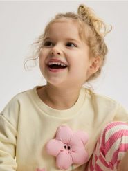 Bluza z aplikacją - kremowy. Białe bluzy i bluzki niemowlęce Reserved, z aplikacjami, z bawełny, bez ramiączek, bez kaptura. Za 55.99 zł.