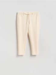 Spodnie chino slim fit - złamana biel. Spodnie materiałowe męskie Reserved, bez wzorów, z bawełny. W wyprzedaży za 69.99 zł.