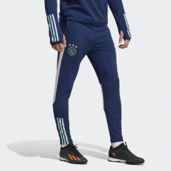 Spodnie do piłki nożej męskie Adidas Ajax Amsterdam Tiro 23 Training Pants. Niebieskie spodnie materiałowe męskie Adidas, bez wzorów, z materiału, klasyczne. Za 234.10 zł.