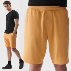 SPODENKI MĘSKIE DRESOWE 4F SPORTOWE BAWEŁNIANE PRZED KOLANO KOLOR POMARAŃCZOWY. Brązowe szorty męskie 4f, na lato, bez wzorów, z bawełny, eleganckie. Za 79.99 zł.