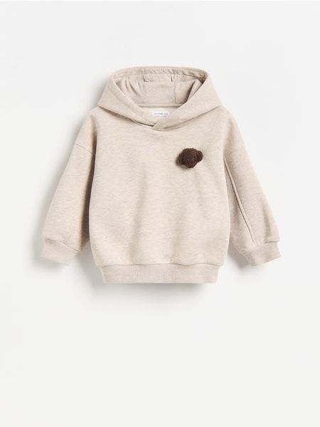 Bawełniana bluza z aplikacją - beżowy. Brązowe bluzy i bluzki niemowlęce Reserved, z aplikacjami, z bawełny, bez ramiączek, bez kaptura. Za 59.99 zł.