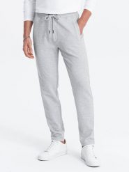 Męskie spodnie dresowe o marchewkowym kroju - szary melanż V3. Szare spodnie dresowe męskie Ombre Clothing, bez wzorów, z dresówki. W wyprzedaży za 59.99 zł.