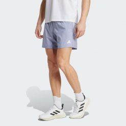 Szorty Own The Run. Szare szorty męskie Adidas, z materiału, bez kołnierzyka. W wyprzedaży za 161.65 zł.