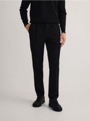 Spodnie slim fit z kantem - czarny. Czarne spodnie materiałowe męskie Reserved, bez wzorów, z tkaniny. W wyprzedaży za 139.99 zł.