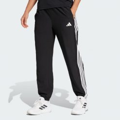 Spodnie Train Essentials 3-Stripes Woven. Zielone spodnie sportowe damskie Adidas, uniwersalny, z dresówki, na fitness i siłownię. Za 219.00 zł.