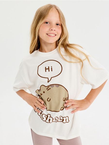 Bawełniana koszulka oversize z nadrukiem Pusheen the Cat - kremowy. Białe koszulki dziewczęce Sinsay, l, bez wzorów, z bawełny, bez ramiączek. Za 17.99 zł.
