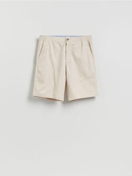 Szorty chino regular - kremowy. Białe szorty męskie Reserved, bez wzorów, z bawełny. Za 129.99 zł.