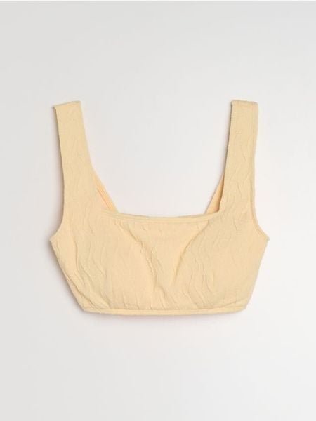 Strukturalna góra od bikini typu beach top - kremowy. Białe bikini damskie Sinsay, bez wzorów. Za 25.99 zł.