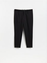 Spodnie chino slim fit - czarny. Czarne spodnie materiałowe męskie Reserved, bez wzorów, z dzianiny. Za 139.99 zł.