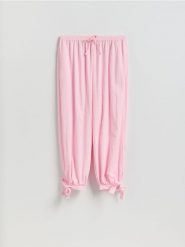 Spodnie z wiązaniami na nogawkach - pastelowy róż. Czerwone spodnie materiałowe damskie Reserved, bez wzorów, z tkaniny. Za 179.99 zł.