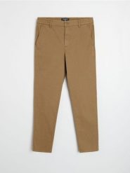 Spodnie chino slim - brązowy. Brązowe spodnie materiałowe męskie Sinsay, bez wzorów. Za 79.99 zł.