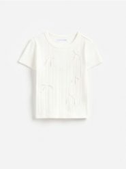 Prążkowany t-shirt z kokardami - złamana biel. Koszulki dziewczęce Reserved, bez wzorów, z bawełny, bez ramiączek. Za 39.99 zł.
