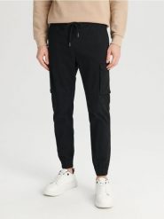 Spodnie jogger - czarny. Czarne spodnie materiałowe męskie Sinsay, bez wzorów, z bawełny. Za 59.99 zł.