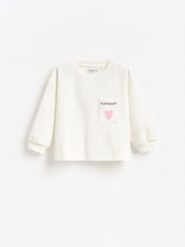 Bawełniana koszulka z kieszonką - złamana biel. Bluzy i bluzki niemowlęce Reserved, m, bez wzorów, z bawełny, bez ramiączek. Za 29.99 zł.