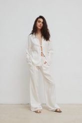 Luźne spodnie z dodatkiem lnu w kolorze SOFT WHITE - ASPRO-XS. Białe spodnie materiałowe damskie Marsala, bez wzorów, z gumy, eleganckie. W wyprzedaży za 99.95 zł.