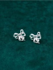 Kolczyki w kształcie kokardek - srebrny. Szare kolczyki damskie Sinsay, srebrne. Za 9.99 zł.