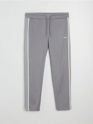 Spodnie dresowe z ozdobnymi taśmami po boku - szary. Szare spodnie sportowe męskie Sinsay, z dresówki. Za 59.99 zł.