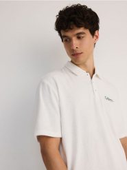 Koszulka polo comfort z napisem - złamana biel. Koszulki polo męskie Reserved, l, bez wzorów, z bawełny, bez ramiączek. W wyprzedaży za 65.99 zł.