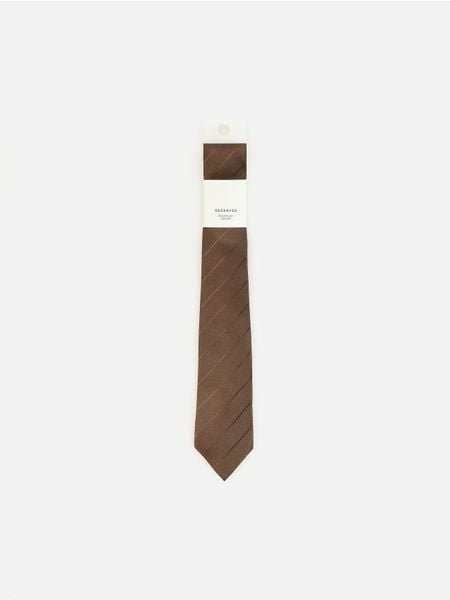 Wąski krawat - ciemnobrązowy. Brązowe krawaty i muchy męskie Reserved, bez wzorów. Za 59.99 zł.