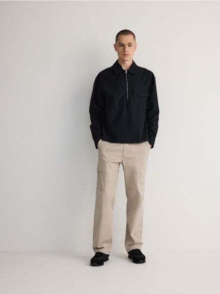 Spodnie cargo - beżowy. Brązowe spodnie materiałowe męskie Reserved, bez wzorów, z bawełny. W wyprzedaży za 49.99 zł.