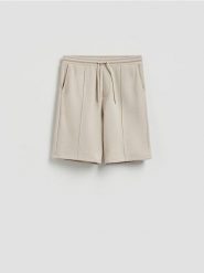 Szorty regular fit z włóknem bambusowym - beżowy. Brązowe szorty męskie Reserved, z dzianiny, bez kołnierzyka. Za 119.99 zł.
